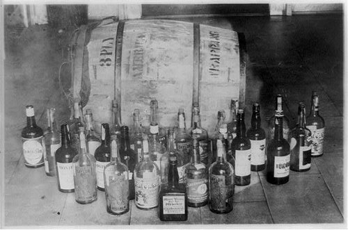 Bottles and barrel of confiscated whiskey